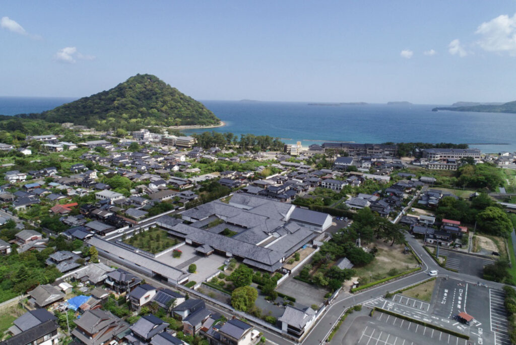 萩まちじゅう博物館のコア博物館（萩博物館）越しにみる指⽉⼭と離島群