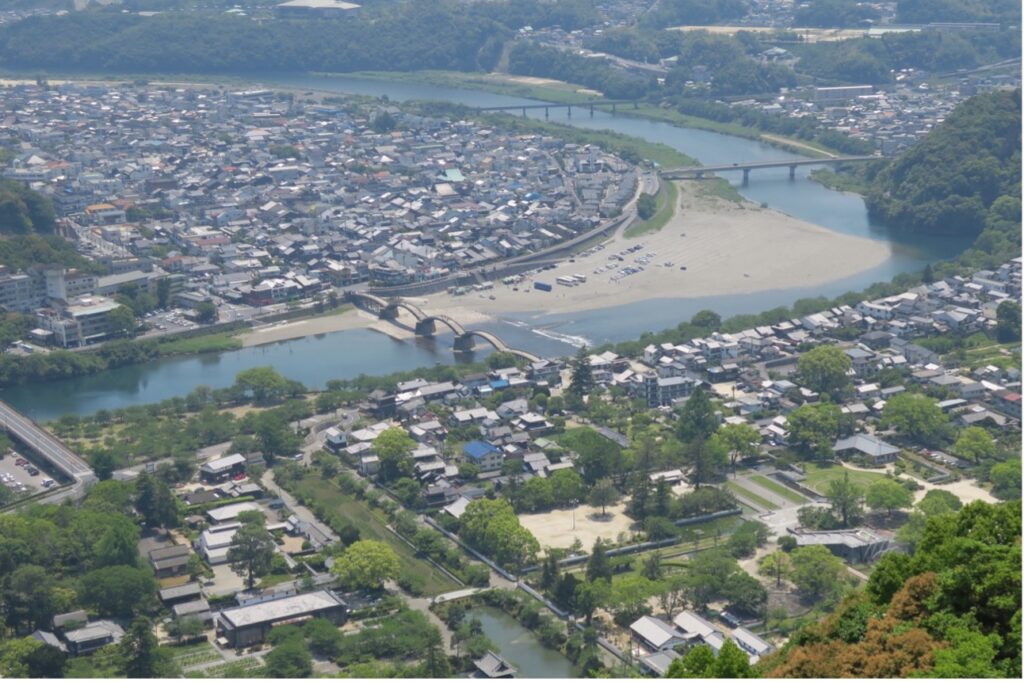 錦帯橋は藩主や上級家臣の住む「横町」（手前）と中下級武士や商人らが住む「錦見」（奥）
を隔てる川幅200mの錦川に「流されない橋」として架けられた
